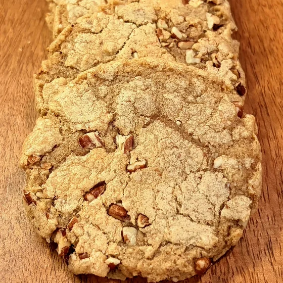 A row of Willow Bakery brown butter pecan cookies on a wooden board